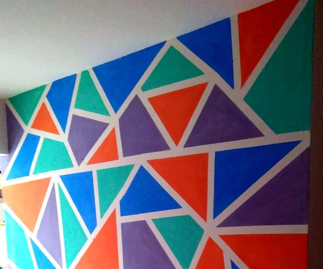 Parede interna pintada com padrão geométrico colorido em triângulos
